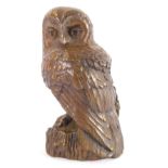 A 20thC Ken Norris bronzed metal figure of an owl, modelled standing on a naturalistic ground, bears
