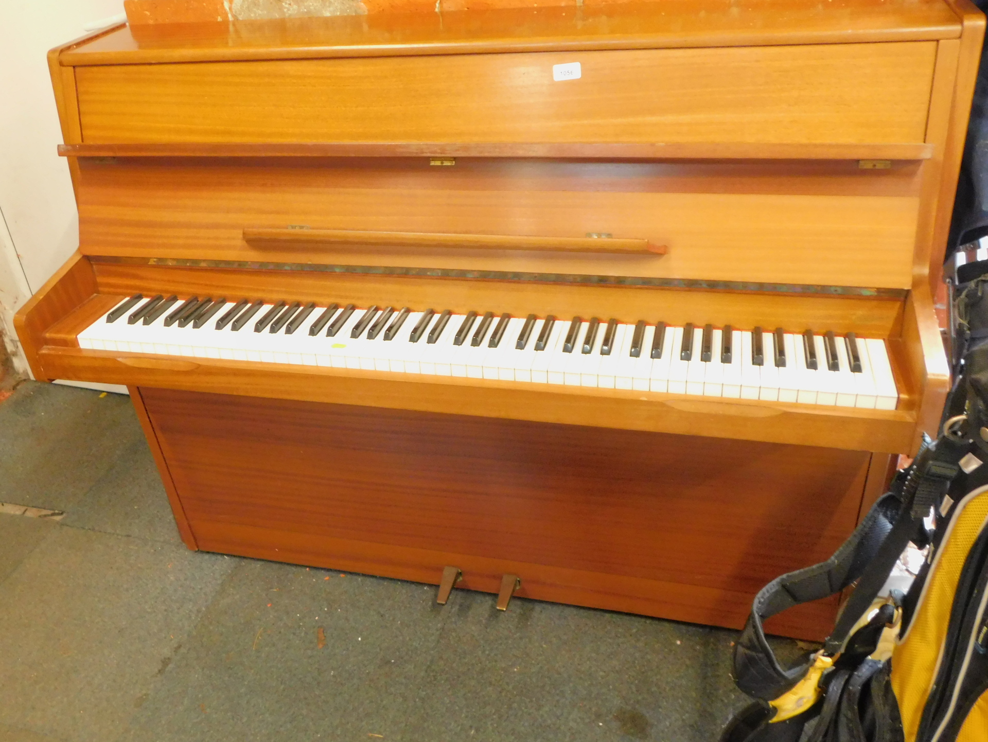 An overstrung upright piano, in teak case.