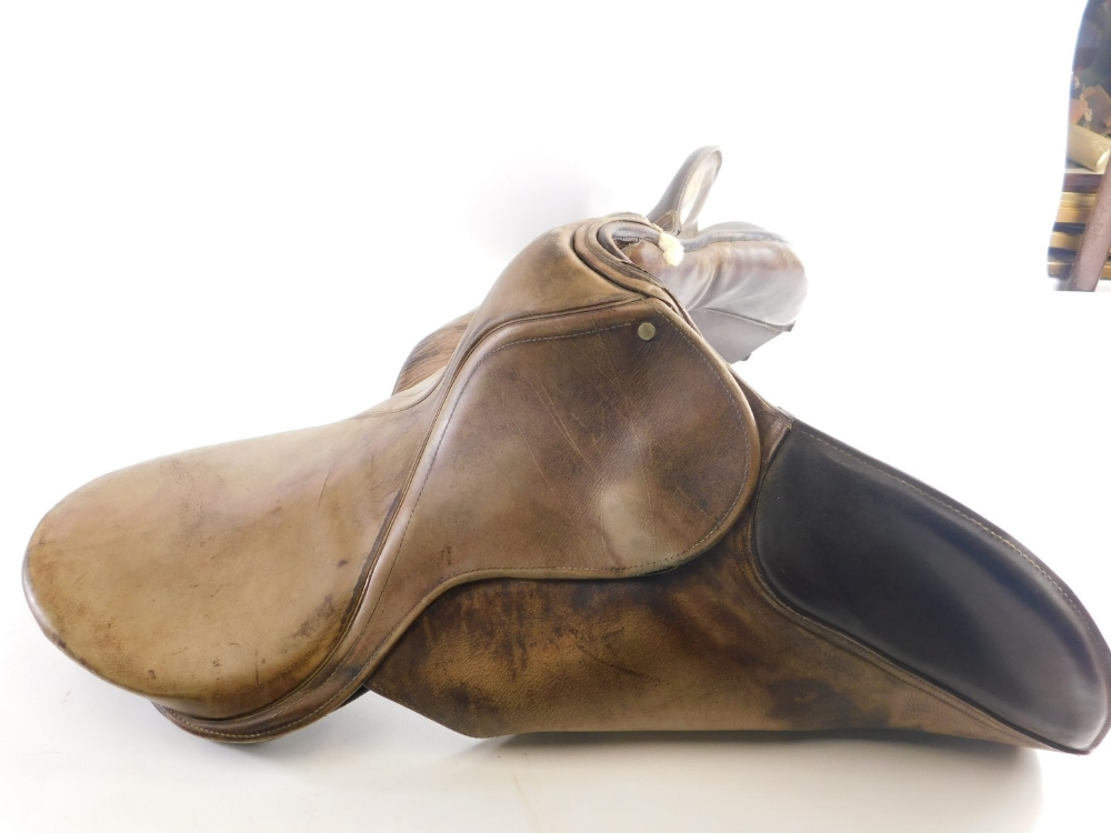 A leather riding saddle with metal mounts, 39cm high.