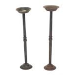 A near pair of wrought iron candle stands, each of ecclesiastical form, on a domed foot, 55cm and 57