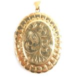 A 9ct gold oval locket, chased with scrolls, with an outer geometric border, with shaped top marked