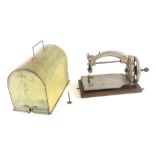 An early 20thC child's sewing machine, with chrome body in tin dome case on wooden base. 22cm high,