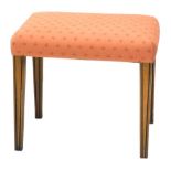 A walnut stool, with a padded seat, on channelled square tapering legs, 52cm wide. The upholstery in