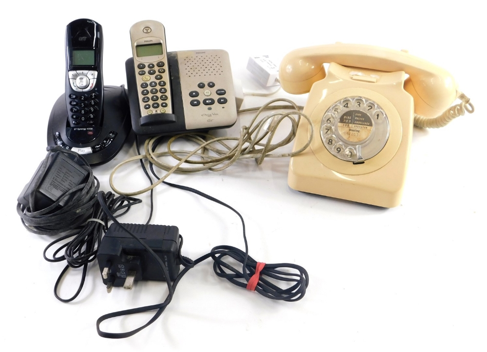 An ivory coloured plastic telephone, with front plastic articulated dial and cord attached receiver,