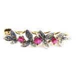 A 9ct gold brooch, claw set with pink stones, with an arrangement of leaves set with small white sto