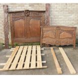 A Continental oak bed head and associated footboard, the elaborately carved head section with cartou