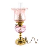 A 20thC oil lamp, with amethyst coloured shade and reservoir, with brass stem, dials marked duplex,