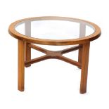 A G-Plan style teak circular coffee table, with smoked glass top and X shaped support, 71cm diameter