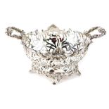 An Edward VII silver basket, by William Comyns, with pierced floral body, and scroll handle, on quad