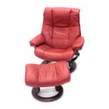 A Stressless style red leather swivel armchair, on shaped supports, and a matching stool.