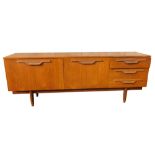 A 1960s/70s teak low sideboard, with an arrangement of two doors and three drawers, each with carved