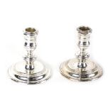 A pair of Elizabeth II squat candlesticks, by Mappin and Webb, each on stepped circular bases, Londo