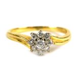 An 18ct gold diamond cluster ring, set with an arrangement of nine round brilliant cut stones, the c
