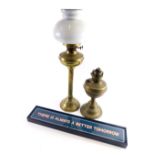 An early 20thC brass oil lamp, with milk class shade on fluted stem, 58cm high, another oil lamp and