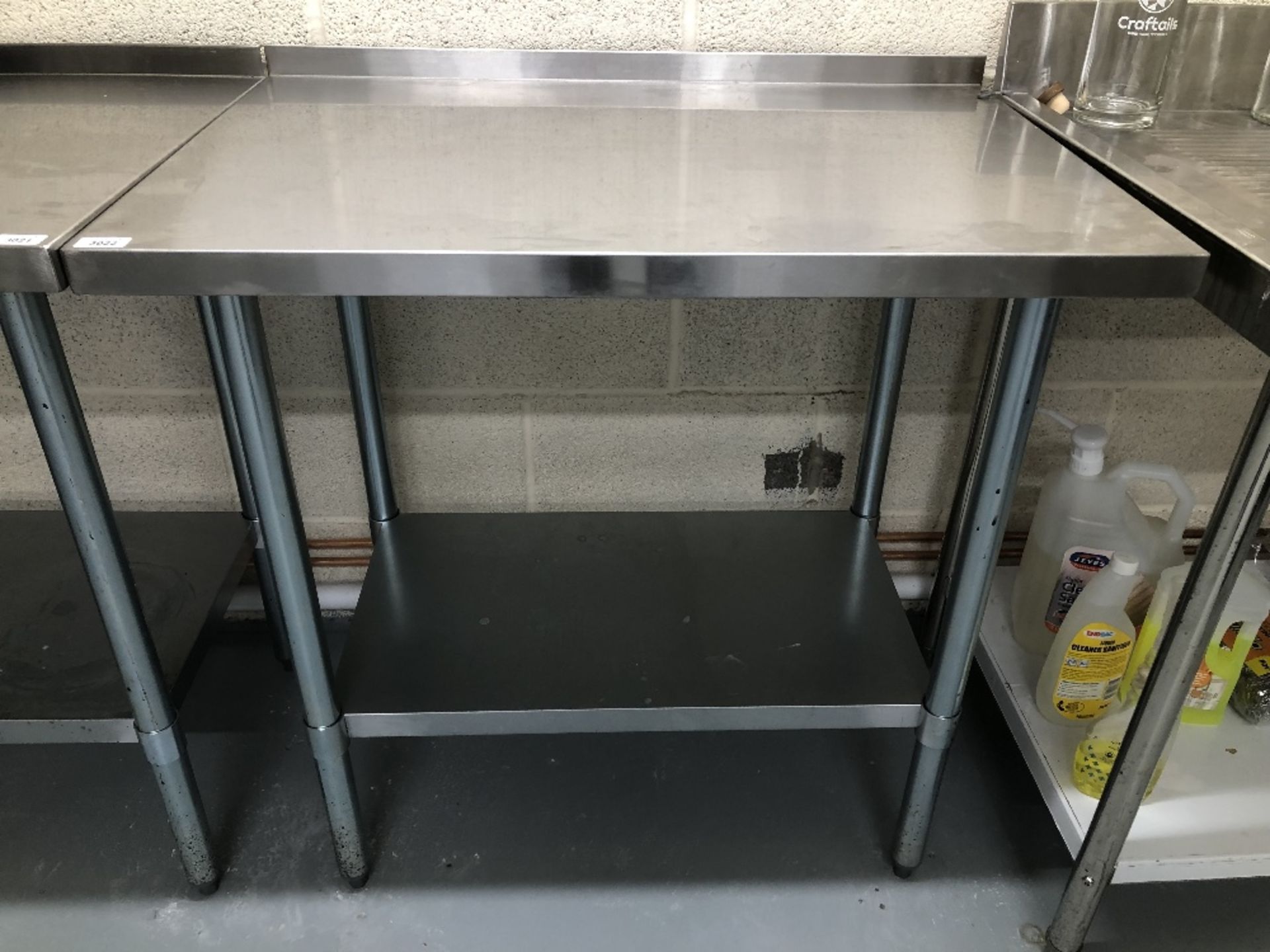 A stainless steel preparation table, 90cm x 60cm, with rear lip. Note: VAT is payable on the hammer