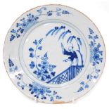 A late 18thC English tin glazed pottery blue and white plate, chinoiserie decorated with a figure in