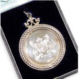 A George V silver presentation medallion, engraved with the coat of arms and partial motto of the Ma