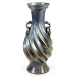 A large Japanese bronze vase, the body with relief spiral twist and loose ring animal head handles,