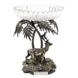 A 19thC silver plated centrepiece modelled as a stag standing beneath two palm trees, with a circula