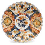 A late 19thC Imari scalloped dish, with a central floral medallion within reserves of flower heads a