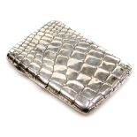 An early 20thC silver cigarette case, of simulated crocodile skin form, hallmarks rubbed, 2.01oz, 11
