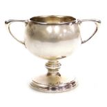An Edwardian VII silver trophy, the bowl of circular form with angular handles, on a circular foot,