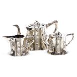 A 19thC Chinese export silver three piece tea set, of naturalistic trunk form, embossed in high and