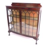 An Edwardian mahogany bow front display cabinet, with Gothic astragal glazed doors, enclosing two sh