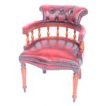 A reproduction mahogany and red leather smokers bow chair, with a serpentine seat, raised on turned