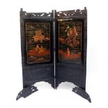A late Victorian japanned lacquered two fold screen, carved with bamboo and decorated with landscape