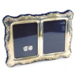An Elizabeth II silver double strut photograph frame, embossed with flowers, apertures 8 x 5.5cm eac