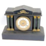A Victorian black slate mantel clock, with an arched top with applied brass bow, with four column su