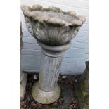 A reconstituted stone bird bath, with leaf moulded top, on a fluted column support, 90cm high, 47cm