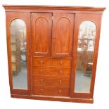 A Victorian mahogany compactum wardrobe, the out swept pediment over a pair of doors enclosing two s