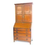 A George III oak and mahogany cross banded bureau bookcase, the outswept pediment over a pair of doo