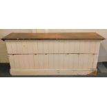 A Victorian stained and white painted shop counter, with a panelled front, raised on a plinth base,