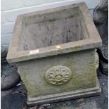 A reconstituted stone square planter, with a ribbed border and floral panels, 36cm high, the top 40c
