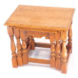 An oak nest of occasional tables, raised on turned legs united by stretchers, largest table 45cm hig