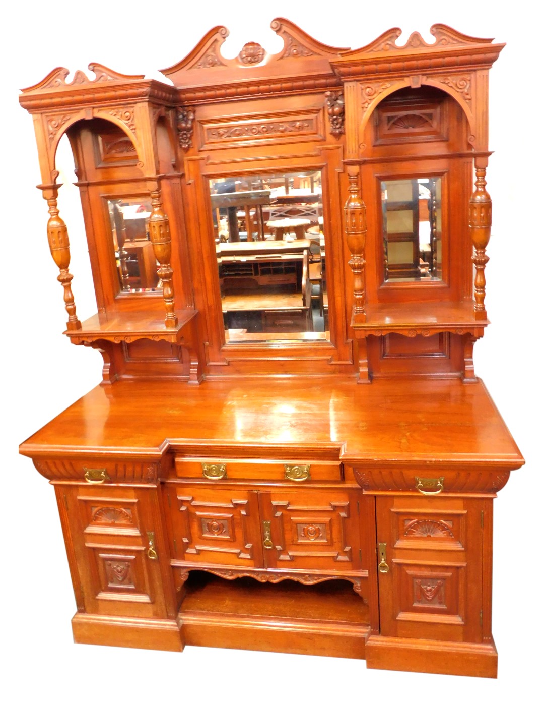 A late Victorian mahogany breakfront sideboard, the triple break arch pediments with foliate carving