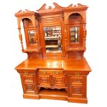 A late Victorian mahogany breakfront sideboard, the triple break arch pediments with foliate carving