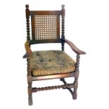 A 19thC Carolean style carver chair, with a carved and cane back, cane and loose cushion seat, raise