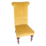 A Victorian mahogany prie dieu chair, upholstered in gold draylon, raised on turned legs, brass capp