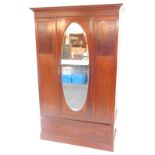 An Edwardian mahogany and line inlaid double wardrobe, the out swept pediment over a central door in