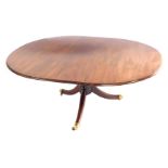 A late Georgian mahogany oval tilt top breakfast table, raised on a turned column, over three out sw