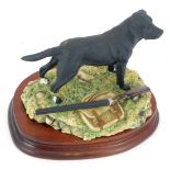 A Border Fine Arts figure of a black Labrador, near hunting bag and rifle, stamped BFA Scotland, dat