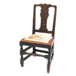 A Victorian carved oak dining chair, the crest and splat decorated with a vase of flowers and leaves