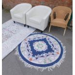 Two cream leatherette tub chairs, a wicker chair and two rugs. (5)