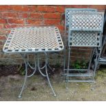 A square cast garden table and two folding chairs.