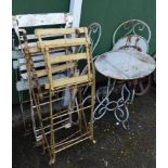 A cast oval garden table and two chairs, and three wooden deck chairs.