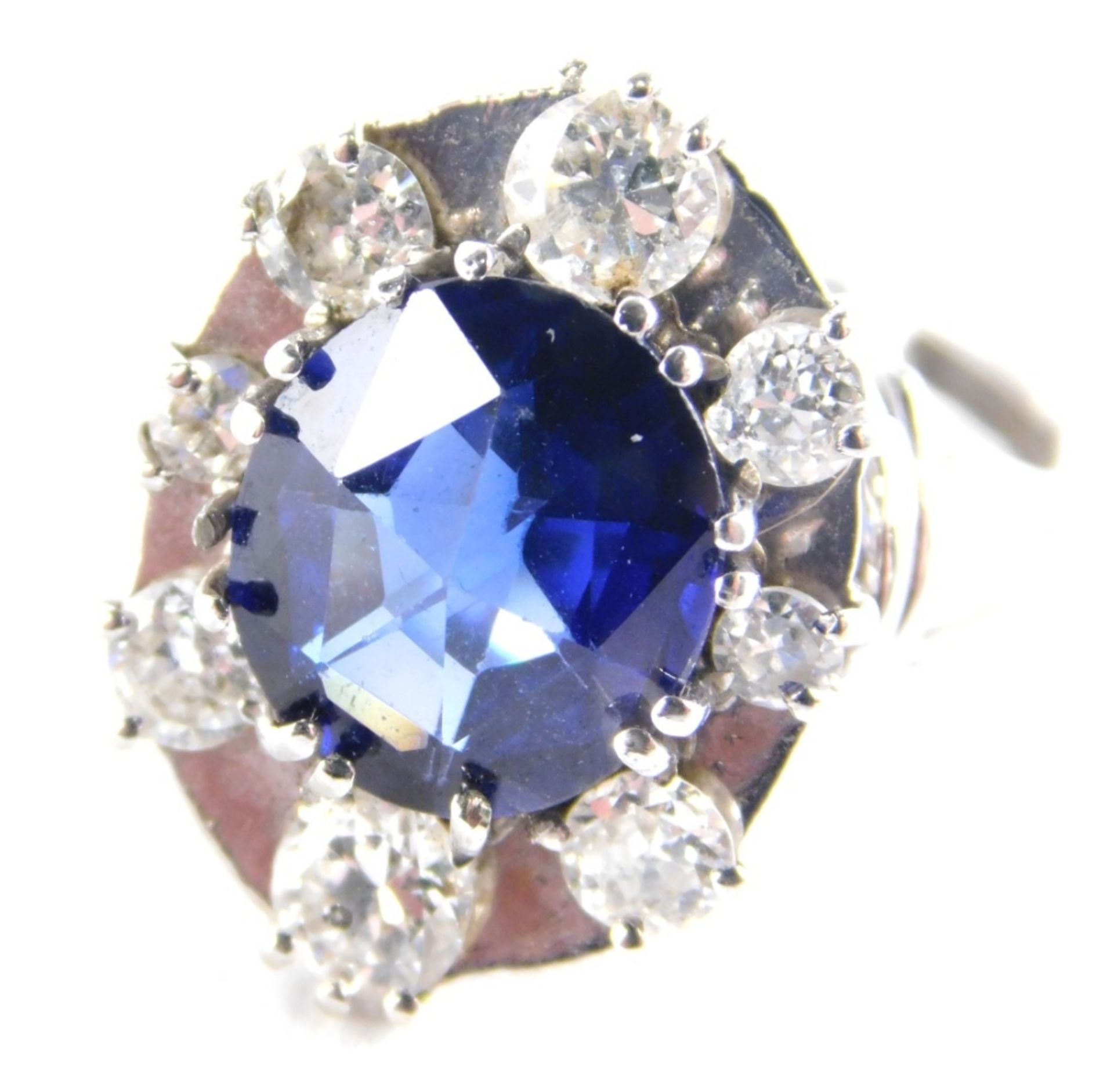 A synthetic sapphire and diamond set dress ring, the oval cut synthetic sapphire 11.4mm x 9.6mm x 5.